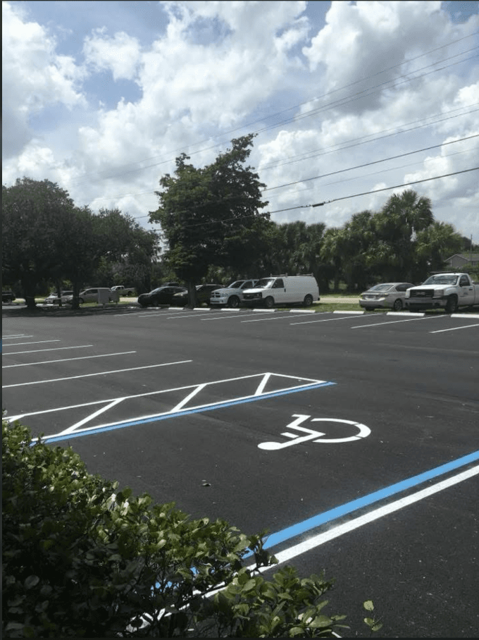 Newly painted ADA-compliant accessible parking space with handicap symbol and blue access aisle