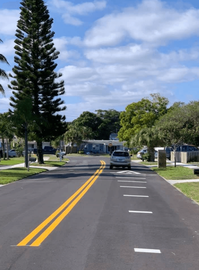 Newly striped neighborhood street with a bright double-yellow centerline and dashed lane lines