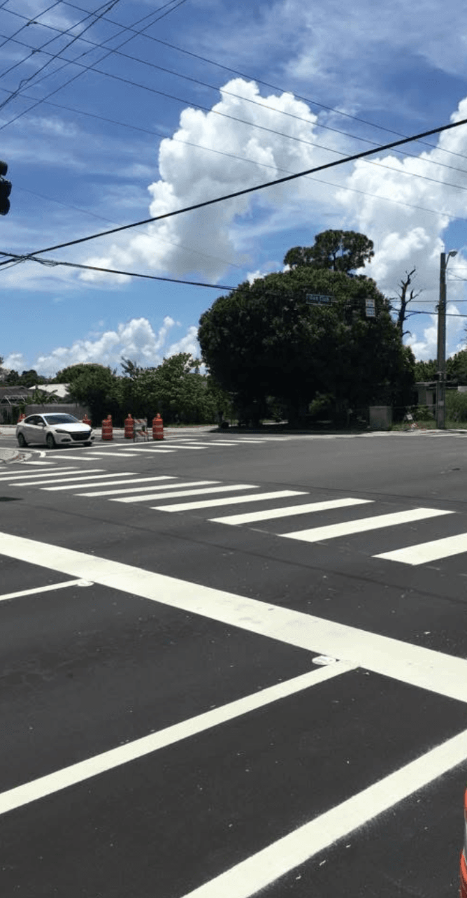 Wide intersection with freshly striped crosswalks, stop bars, and lane markings